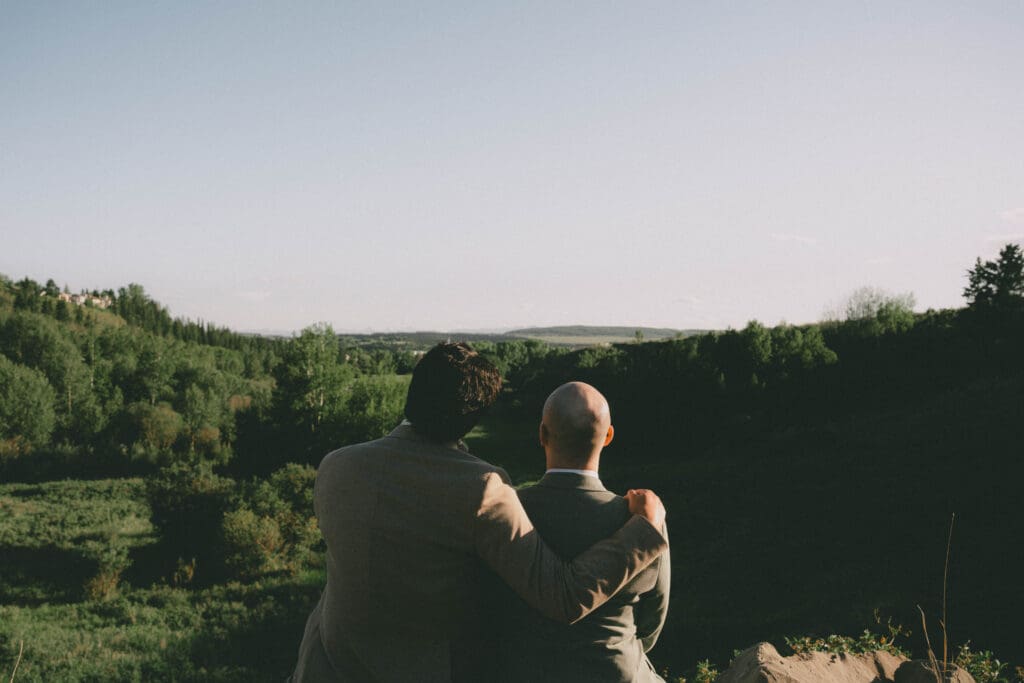 Wedding couple sitting overlooking the valley at Cochrane Ranchehouse Wedding Venue