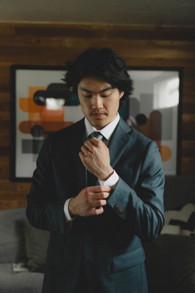 Groom fixing his sleeve on his suit