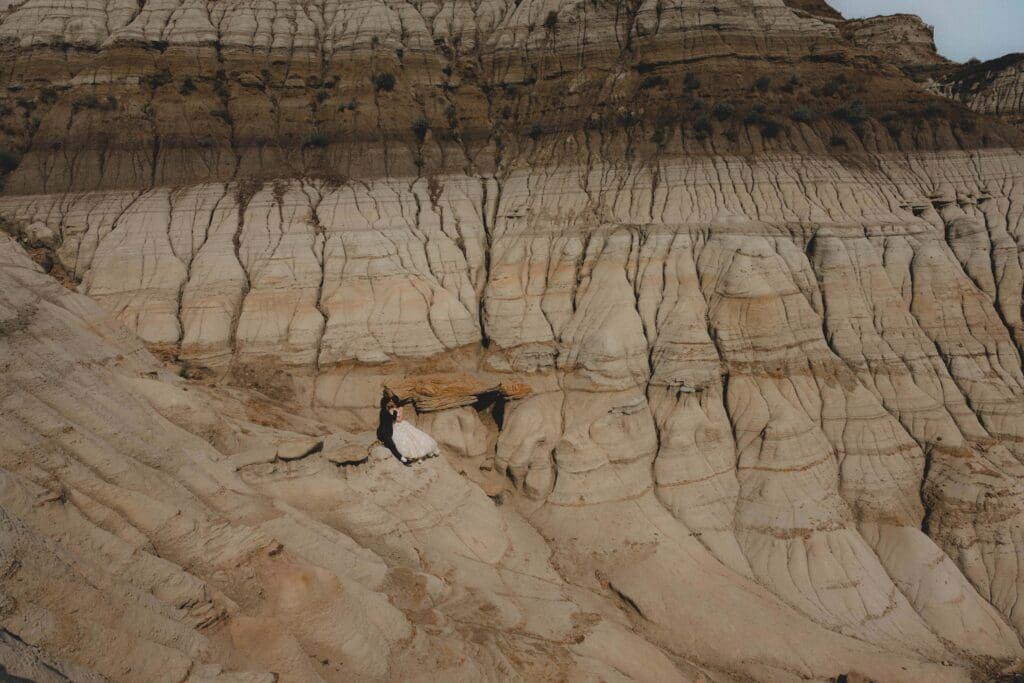 Wedding couple sitting in the Drumheller Hoodoos