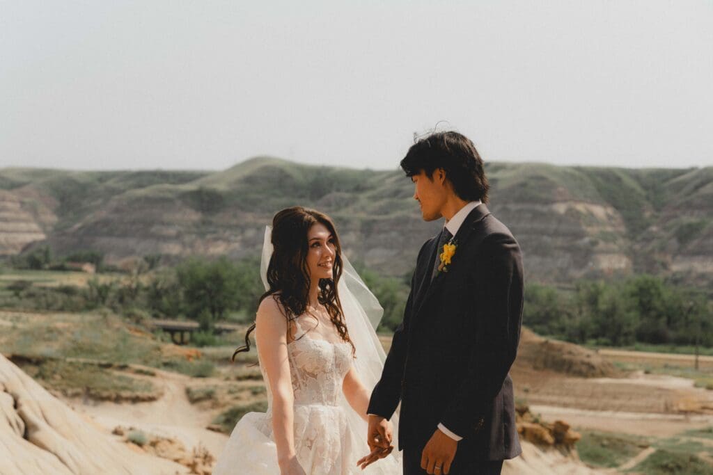 Wedding couple looking at each other in the drumheller hoodoos