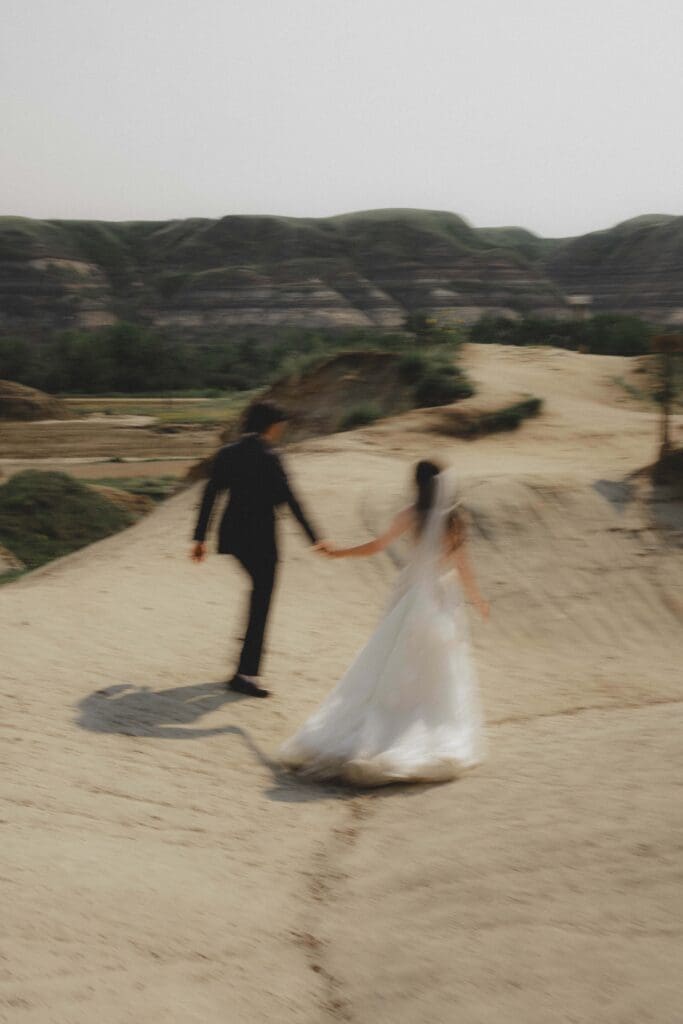 Wedding couple walking through the Drumheller Hoodoos