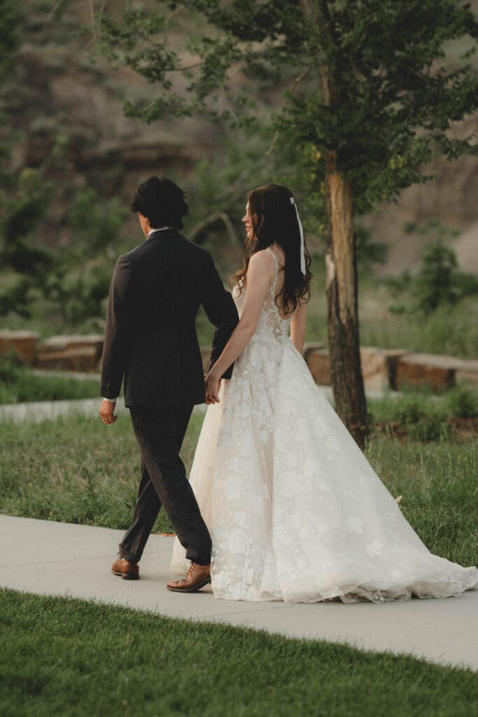 Wedding couple walking through greenery