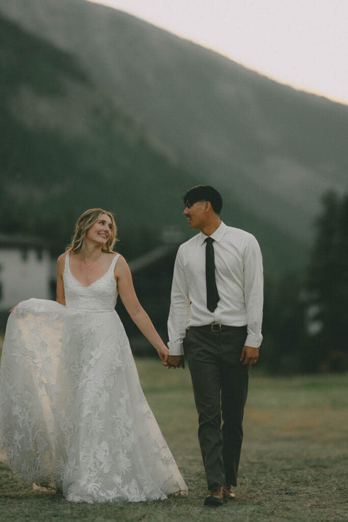 Wedding couple walk and look at each other during sunset