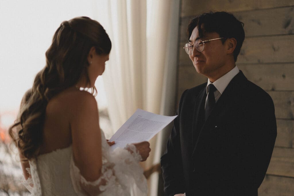 Groom crying as his bride reads a letter to him during their first look