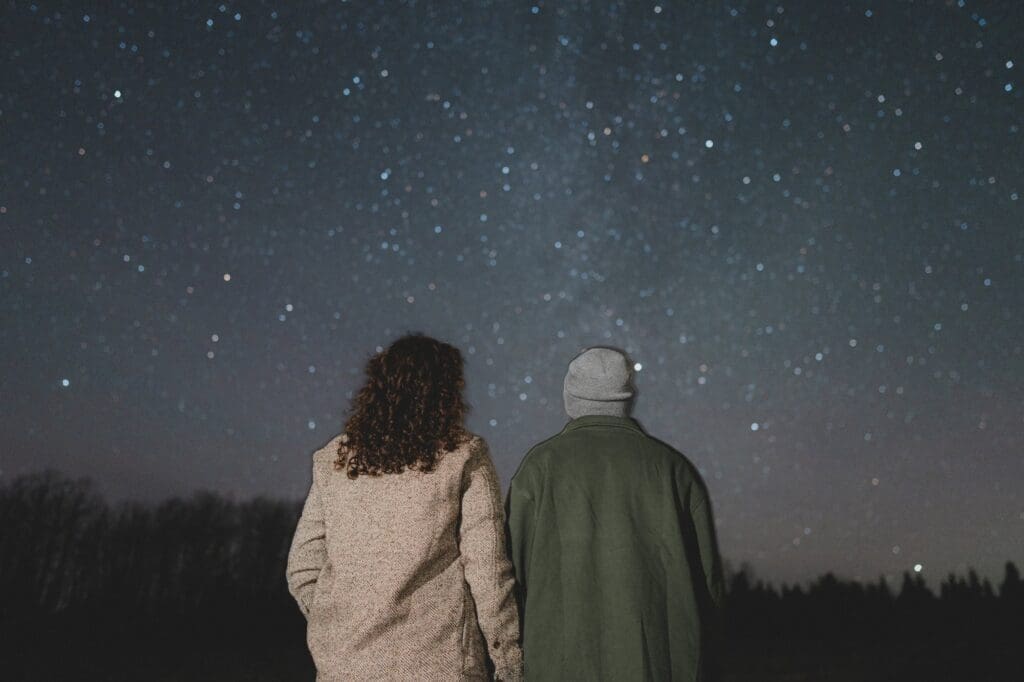 Engaged couples looking up at the stars