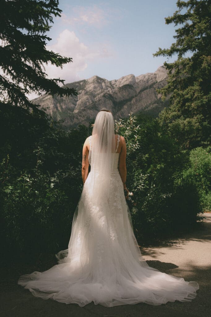Bride looking up at mountain in Canmore