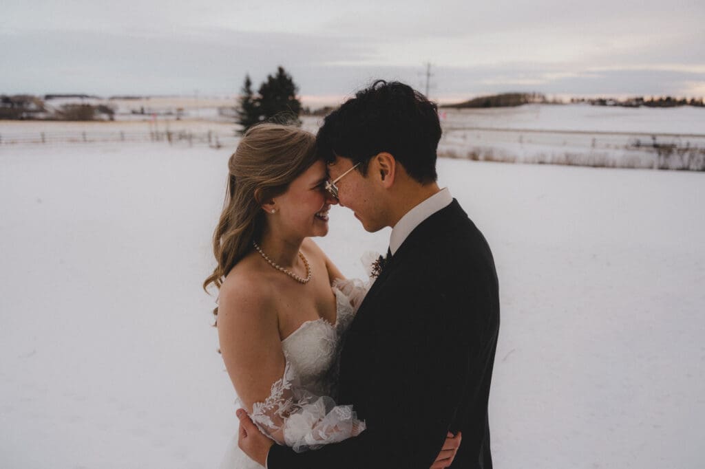 Wedding couple looking at each other in a winter snowy prairie